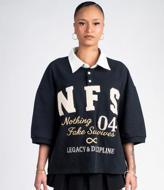 Female model wearing a black oversized shirt with text and a black skirt on a white background