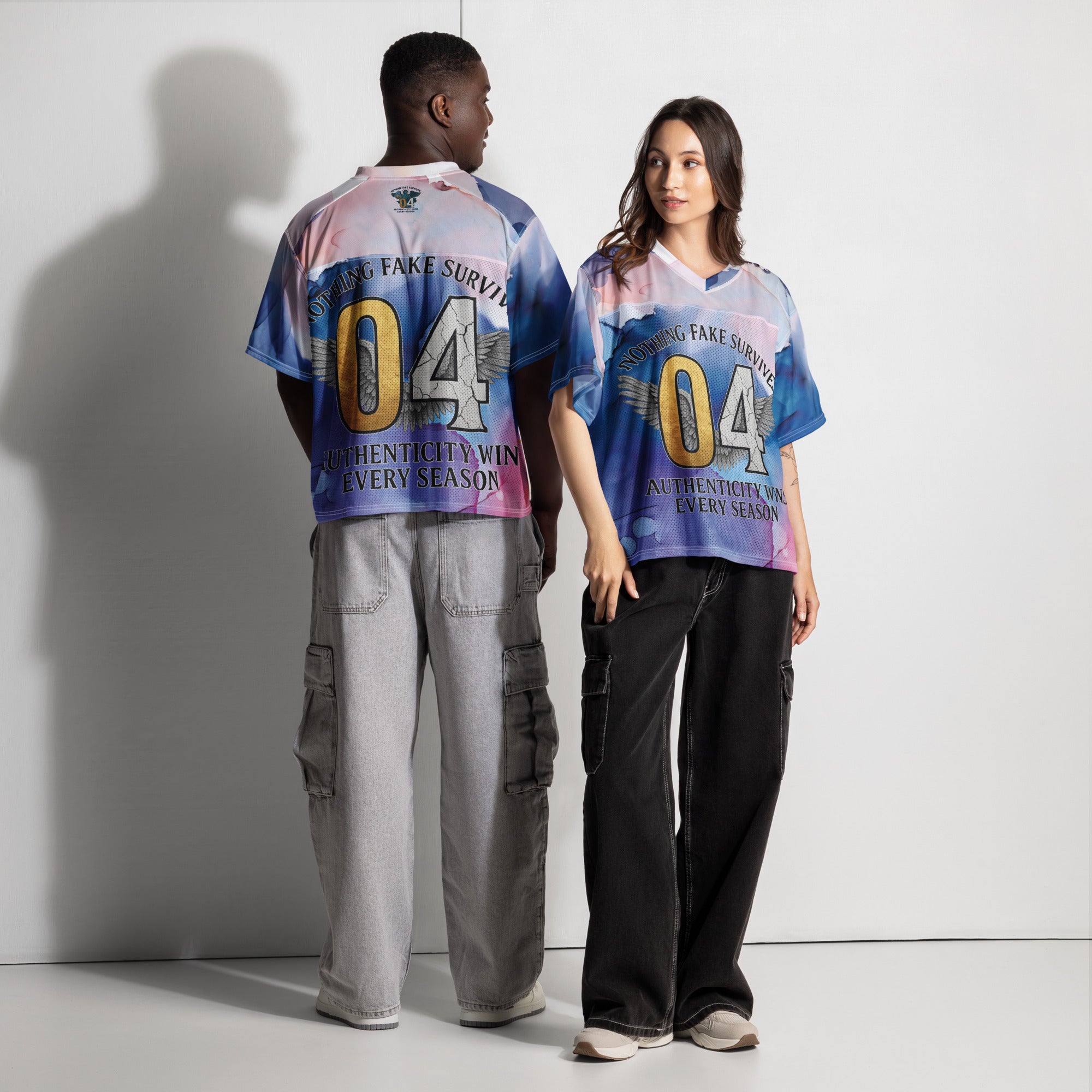 Two people wearing matching colorful jerseys with text and numbers on a plain background